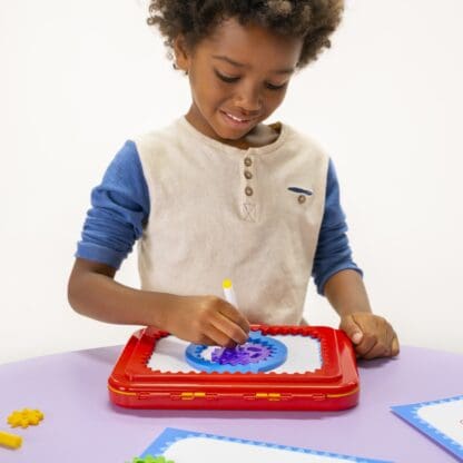 Boy drawing with Spirograph Jr.
